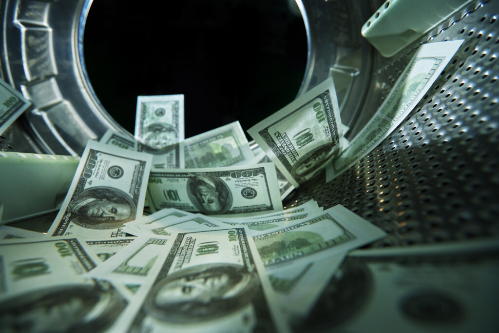 U.S dollars inside a washing machine , symbolizing money laundering.